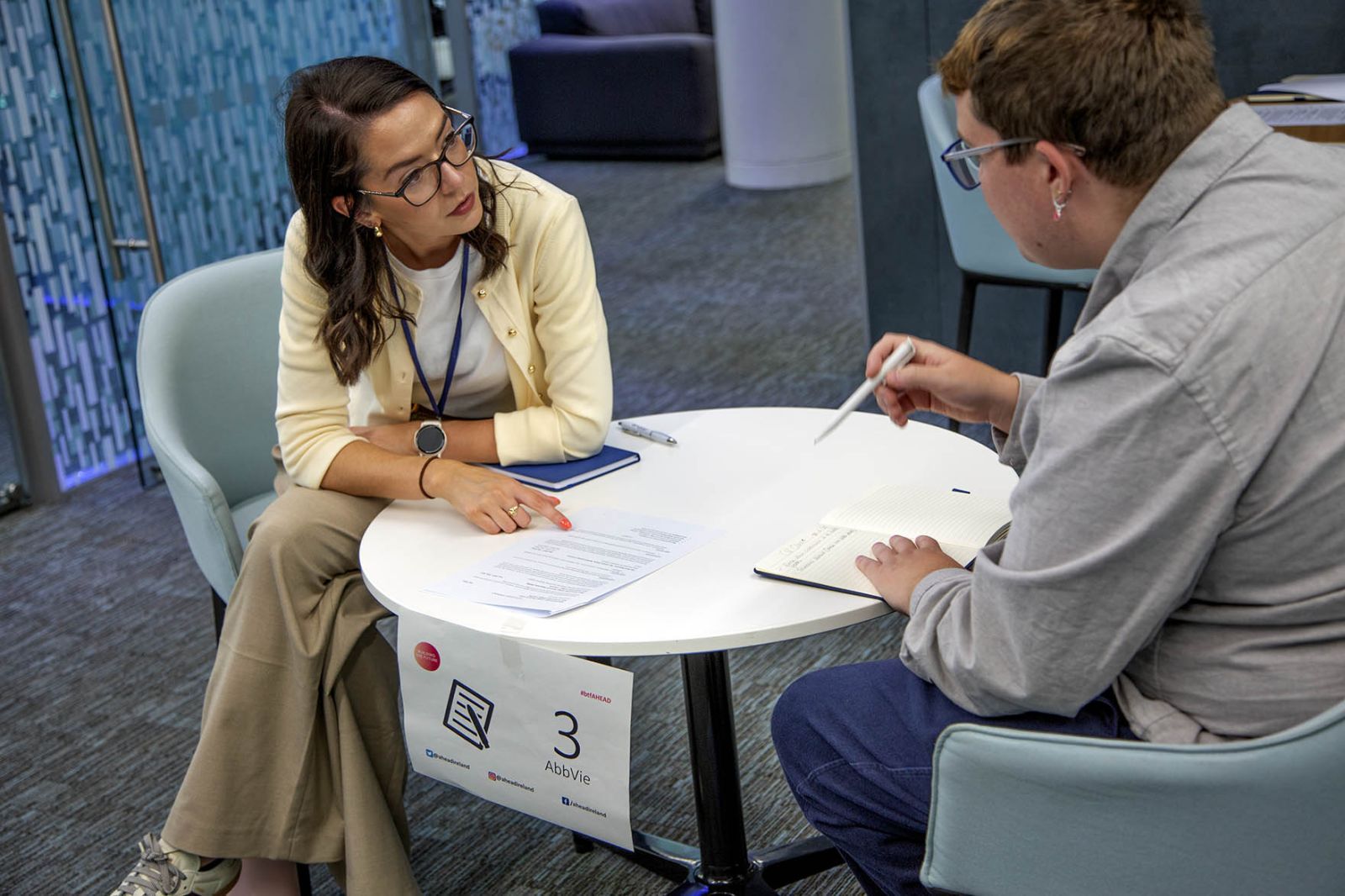 Photograph shows an employer and student discussing their CV.
